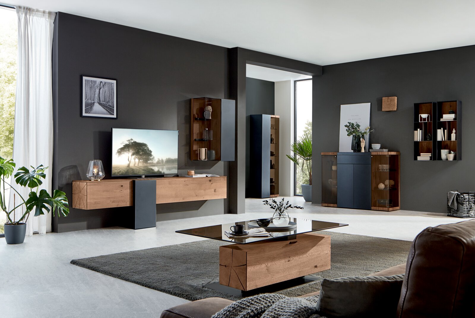 Moderne Wohnzimmer-Wandkombination in Holzoptik mit dunklen Akzenten, seitliche Perspektive