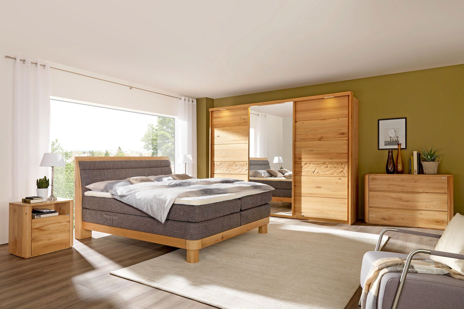 Schlafzimmer mit Schwebetürenschrank aus Holz, Bett und Nachttisch, seitliche Perspektive