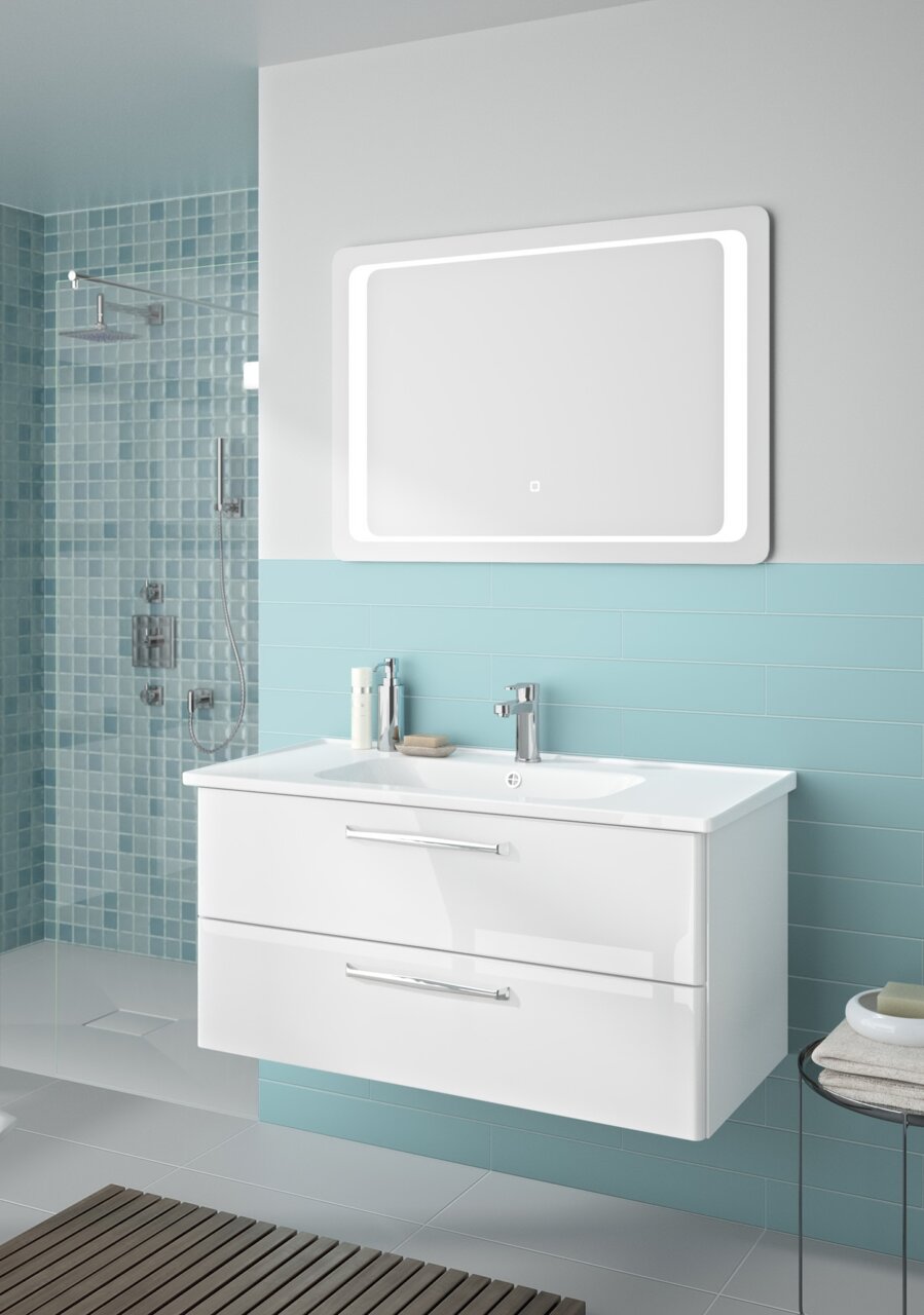 Moderner Badblock mit zwei Schubladen und integriertem Waschbecken, frontal betrachtet, vor einer Wand mit blauen Fliesen.