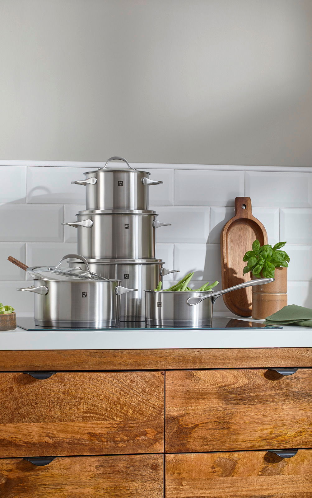 Topfset Essence 5-tlg. aus Edelstahl, gestapelt auf einer Küchenarbeitsplatte, seitliche Perspektive