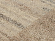 Nahaufnahme eines Wollteppichs mit natürlichen Beige- und Brauntönen, diagonale Perspektive