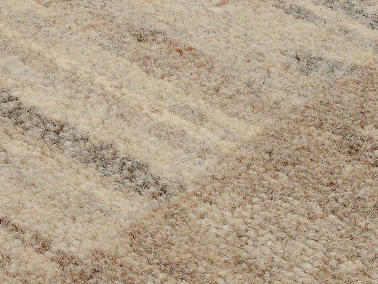 Nahaufnahme eines Wollteppichs mit natürlichen Beige- und Brauntönen, diagonale Perspektive
