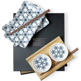 Sushi Set mit blauen Blumenmuster, bestehend aus rechteckigen Tellern und runden Schälchen, mit Essstäbchen auf einer Holzunterlage, aus der Vogelperspektive fotografiert.