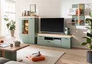 Modernes Highboard in einem Wohnzimmer, grüne Farbe, mit Dekorationen und Beleuchtung, seitliche Perspektive