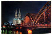 Nachtaufnahme des Kölner Doms und der Hohenzollernbrücke, seitliche Perspektive