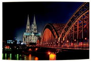 Nachtaufnahme des Kölner Doms und der Hohenzollernbrücke, seitliche Perspektive