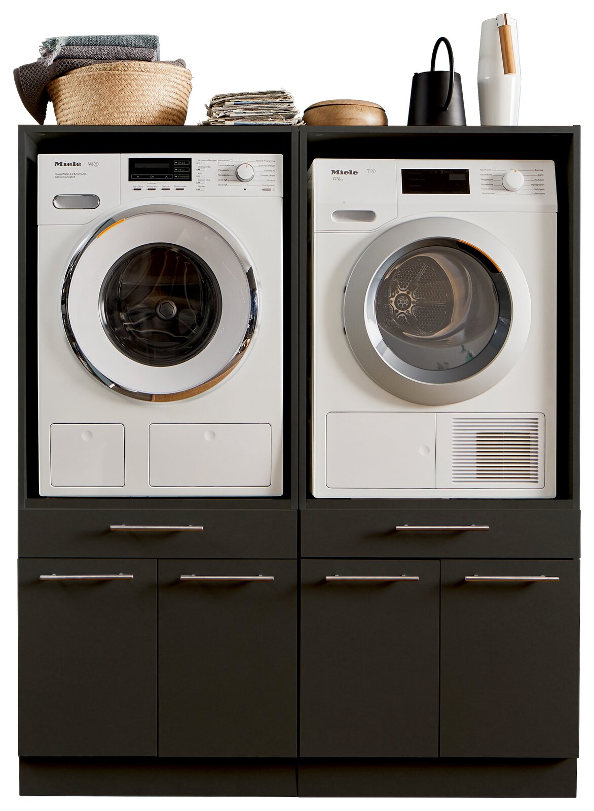 XORA Hauswirtschaftsraum-Kombi PRIMUS Frontansicht einer Hauswirtschaftsraum-Kombination mit Waschmaschine und Trockner, umgeben von dunklen Schränken und dekorativen Elementen oben.