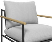 Nahaufnahme eines modernen Gartenstuhls mit hellgrauen Kissen und Holzarmlehnen, seitliche Perspektive.