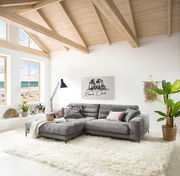 Graue Longchairkombination in einem hellen Wohnzimmer mit großen Fenstern und Blick auf den Strand, aus der Perspektive von vorne links.