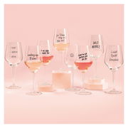 Eine Sammlung von Weingläsern mit humorvollen Sprüchen, gefüllt mit roséfarbenem Wein, auf einem rosa Hintergrund. Die Gläser sind aus der Frontalperspektive zu sehen.