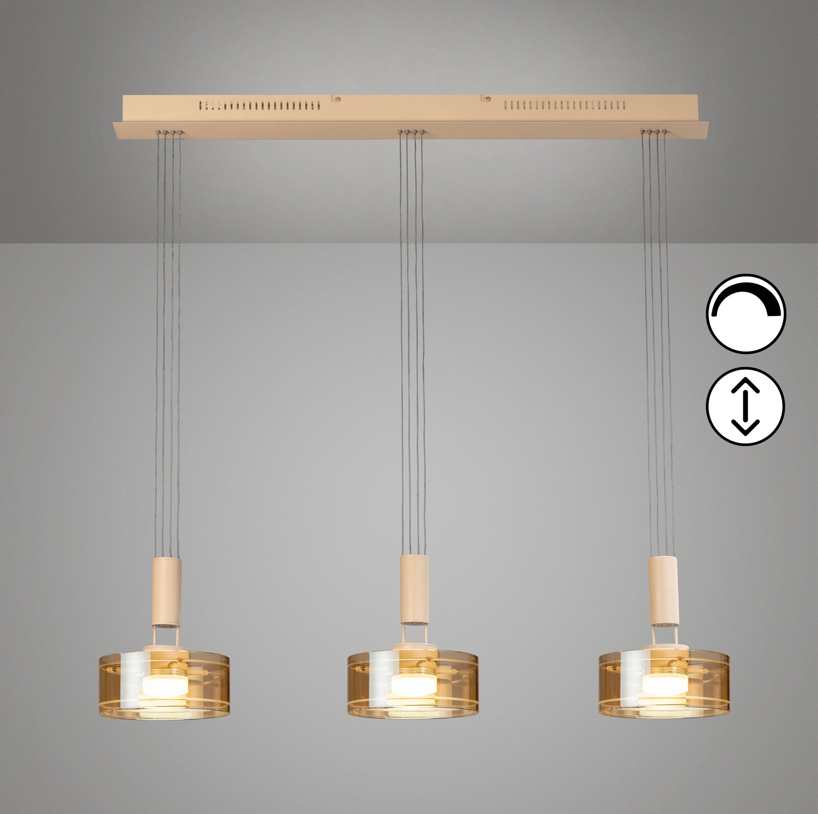 Moderne 3-flammige Pendelleuchte mit drei zylindrischen, amberfarbenen Glasschirmen und beigem Baldachin, frontal von unten an der Decke hängend