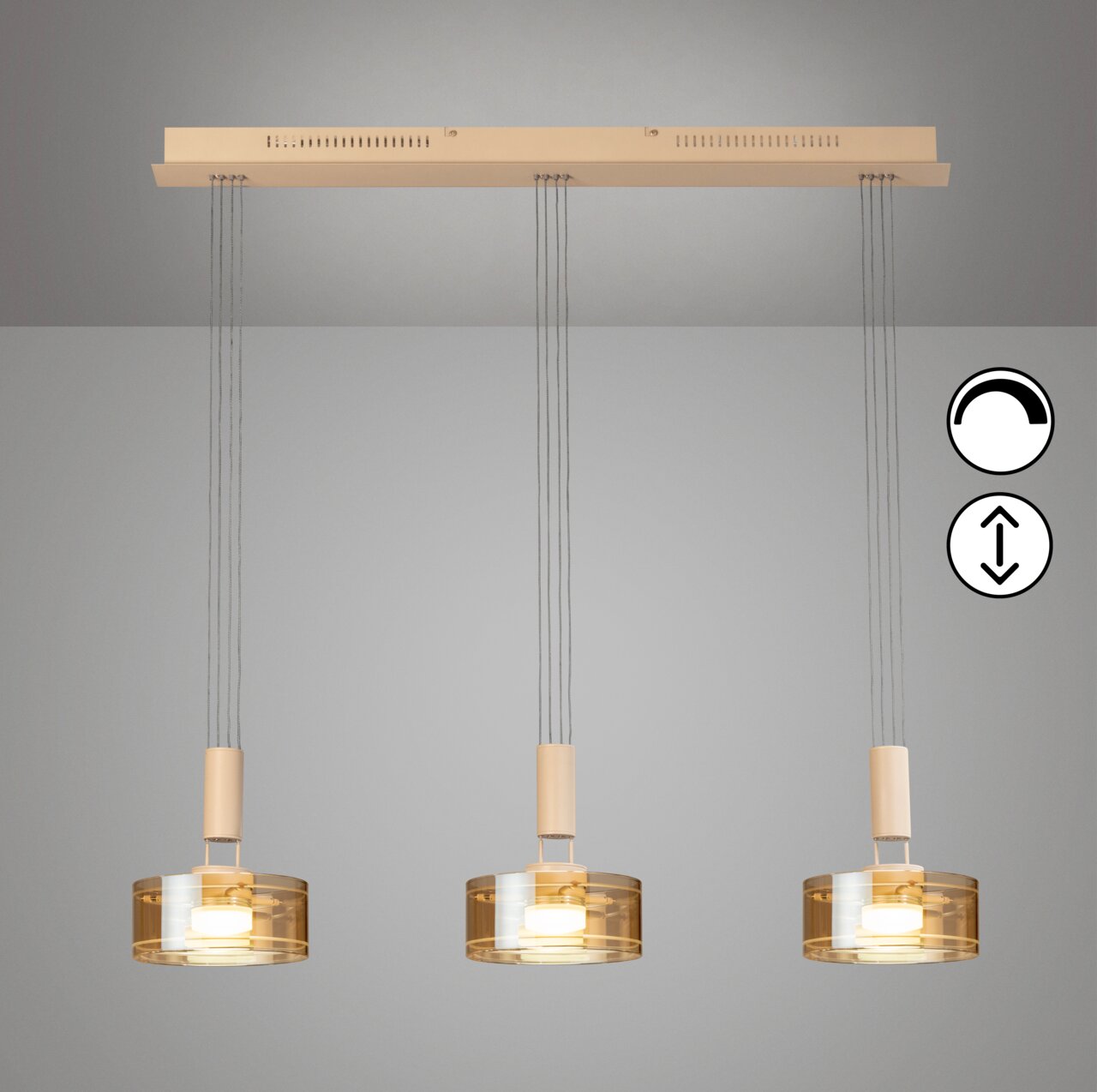 Moderne hanglamp met drie lampen, voorzien van drie cilindervormige, amberkleurige glazen kappen en een beige kap, die vanaf de voorkant onderaan aan het plafond hangt