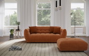 Gemütliches Big-Sofa in warmem Orange, frontal fotografiert, mit passendem Hocker in einem hellen, modernen Wohnzimmer.