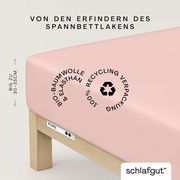 Spannbettlaken in Rosa aus Bio-Baumwolle und Elasthan, geeignet für Matratzen bis zu 30-35 cm Höhe, mit 100% recycelter Verpackung, seitliche Perspektive.