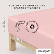 Spannbettlaken in Rosa aus Bio-Baumwolle und Elasthan, geeignet für Matratzen bis zu 30-35 cm Höhe, mit 100% recycelter Verpackung, seitliche Perspektive.