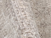 Nahaufnahme eines Designer-Teppichs mit detaillierter Textur und Muster in neutralen Tönen, seitliche Perspektive