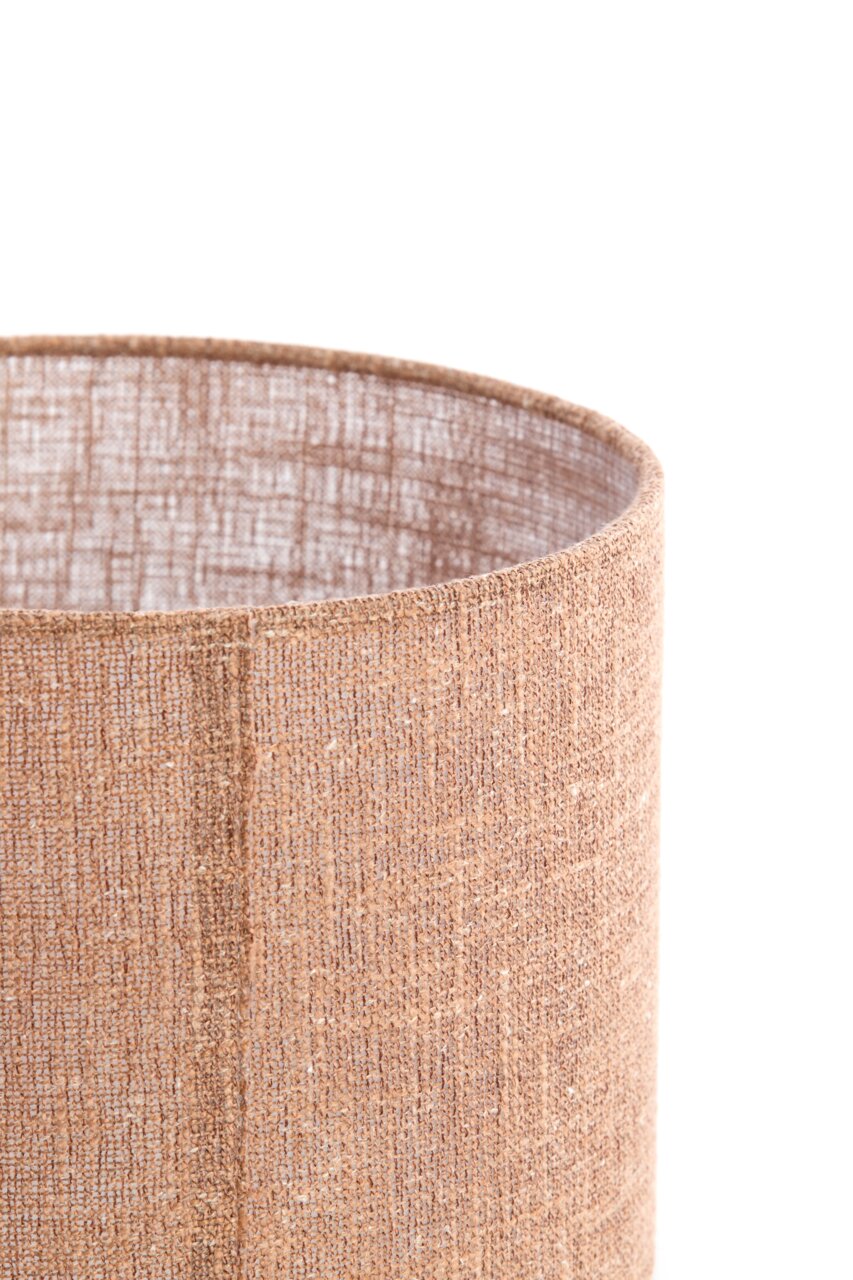 Nahaufnahme eines zylindrischen, beige-braunen Lampenschirms aus strukturiertem Stoff, von der Seite betrachtet.