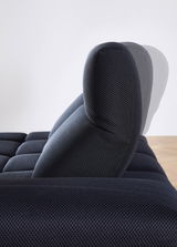 Seitenansicht einer verstellbaren Kopfstütze einer dunkelblauen Eckgarnitur mit strukturiertem Stoffbezug.