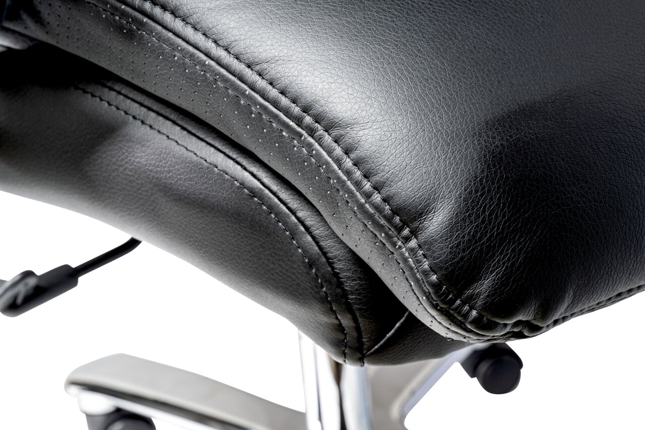 Close-up van een zwarte leren fauteuil met verchroomd frame, gezien vanaf de zijkant