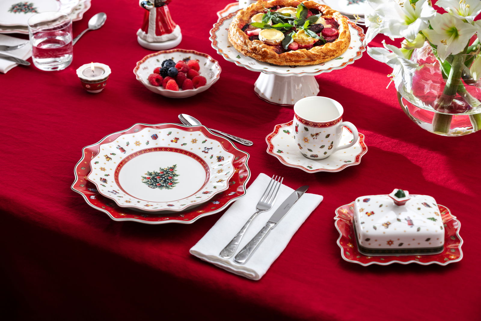 Festlich gedeckter Tisch mit rotem Speiseteller aus der Toy's Delight Kollektion, verziert mit weihnachtlichen Motiven, aus der Vogelperspektive.