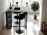 Moderner Bartisch mit schwarzem Metallgestell und Holzplatte, seitlich mit Regalfächern, in einem hellen Raum mit Pflanzen dekoriert, seitliche Perspektive.