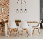 Moderne Hängeleuchte mit drei Käfiglampen über einem Esstisch, seitliche Perspektive