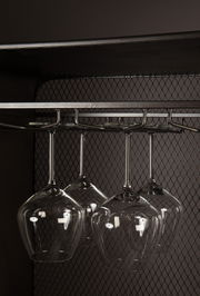 Nahaufnahme eines Weinregals mit hängenden Weingläsern, seitliche Perspektive.