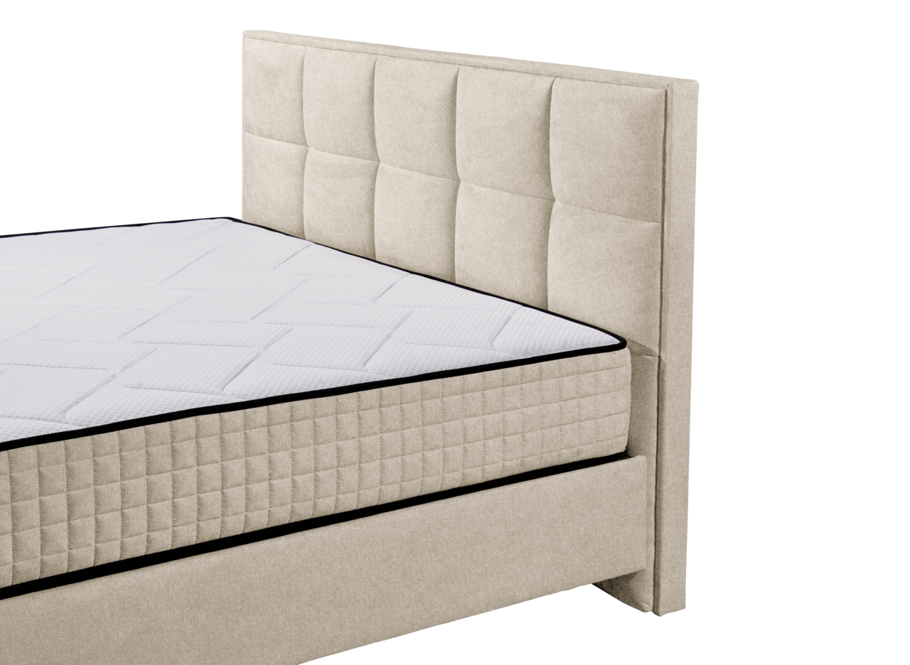 Beige Boxbett mit gestepptem Kopfteil und Matratze, seitliche Perspektive