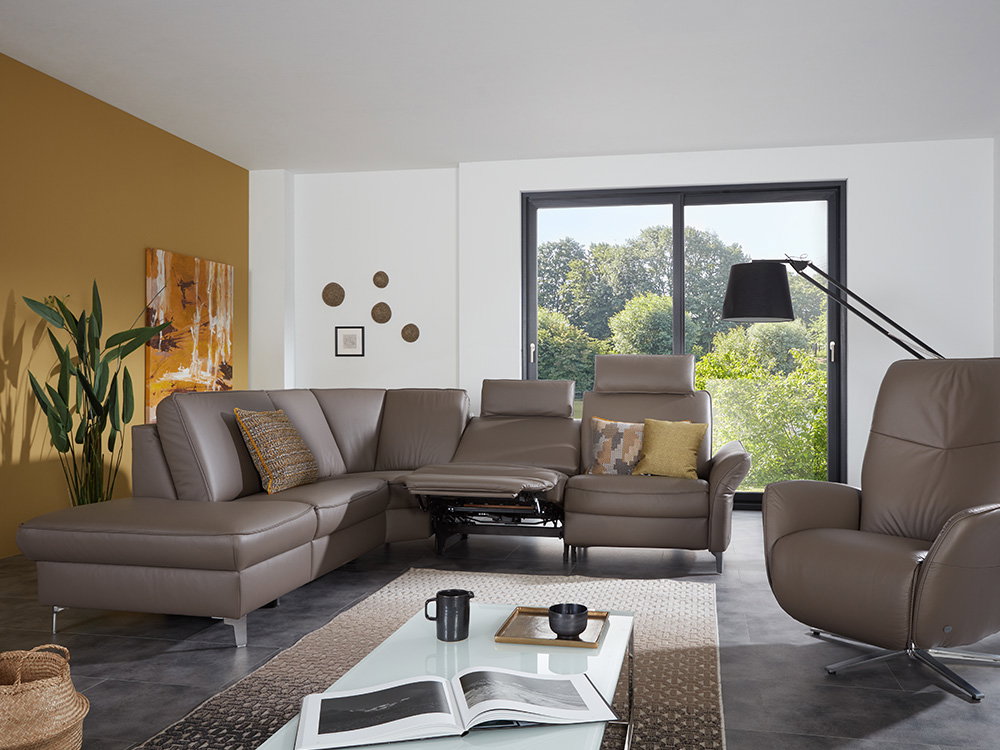 Modernes Wohnzimmer mit braunem Ledersofa, großer Lampe und farbiger Wand
