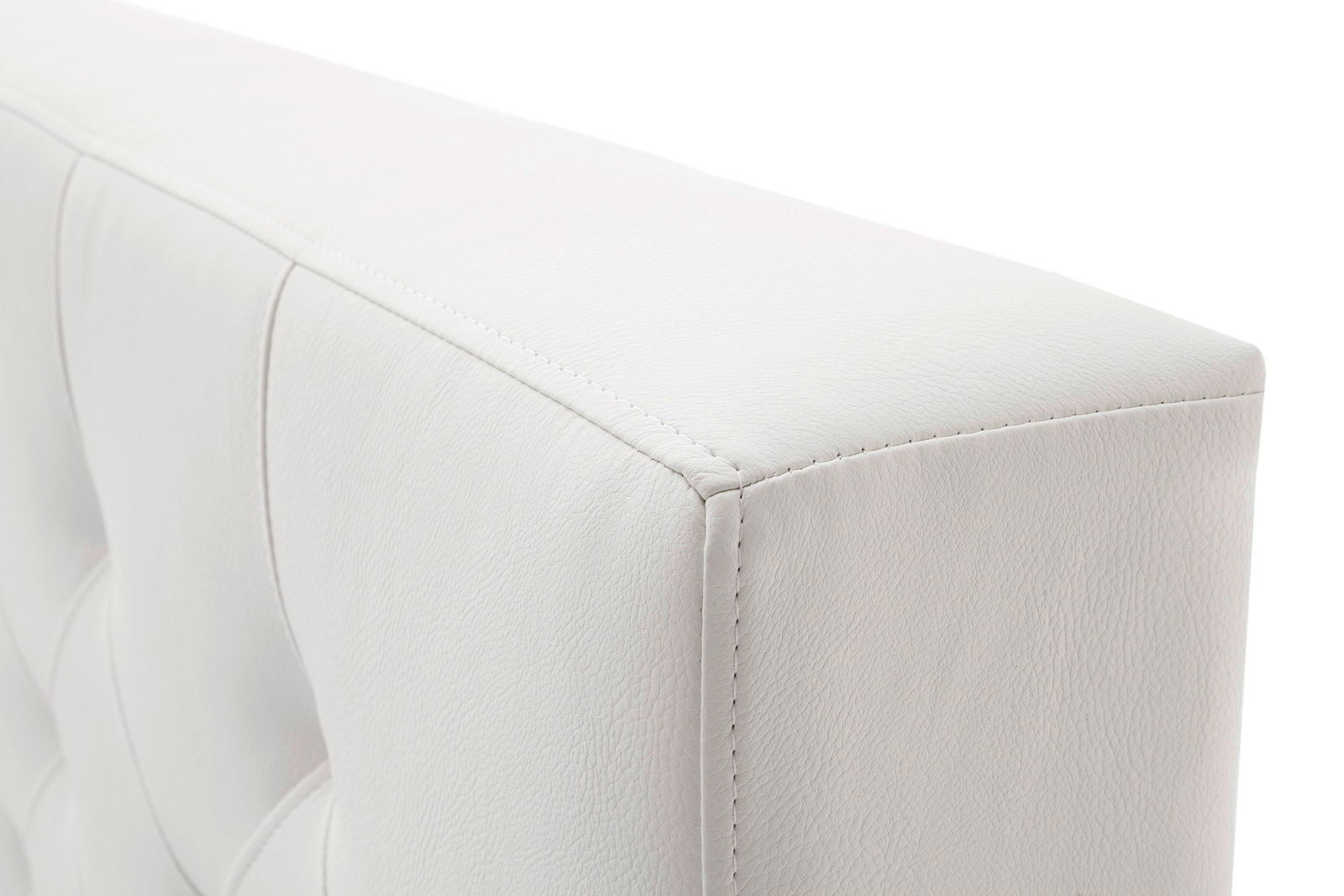 Nahaufnahme eines weißen, gepolsterten Bettrahmens mit sichtbaren Nähten und strukturiertem Material, seitliche Perspektive.