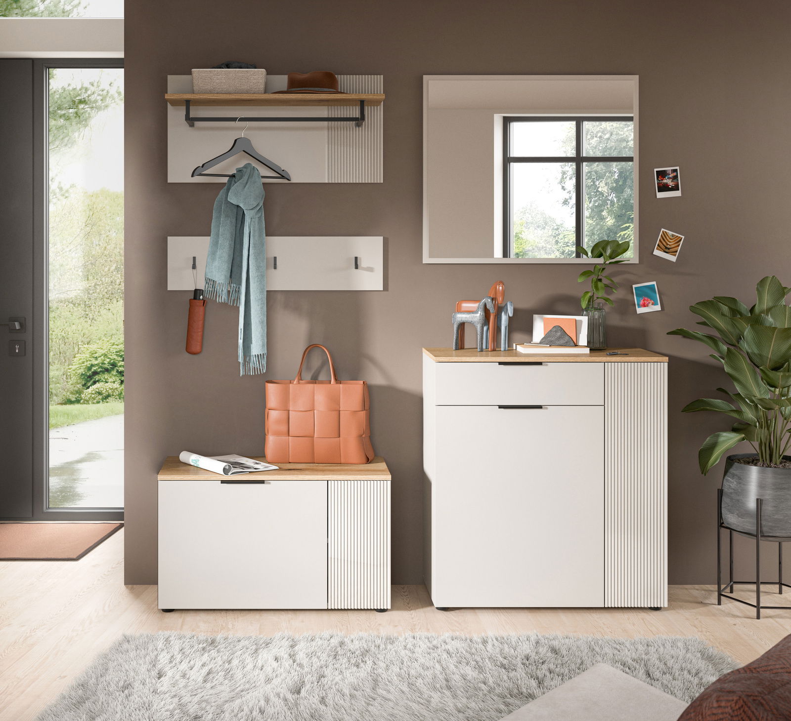 Moderne Garderobenkombination in einem Flur mit Spiegel, Kleiderhaken, Schuhschrank und Dekorationen, aus der Perspektive von vorne betrachtet.