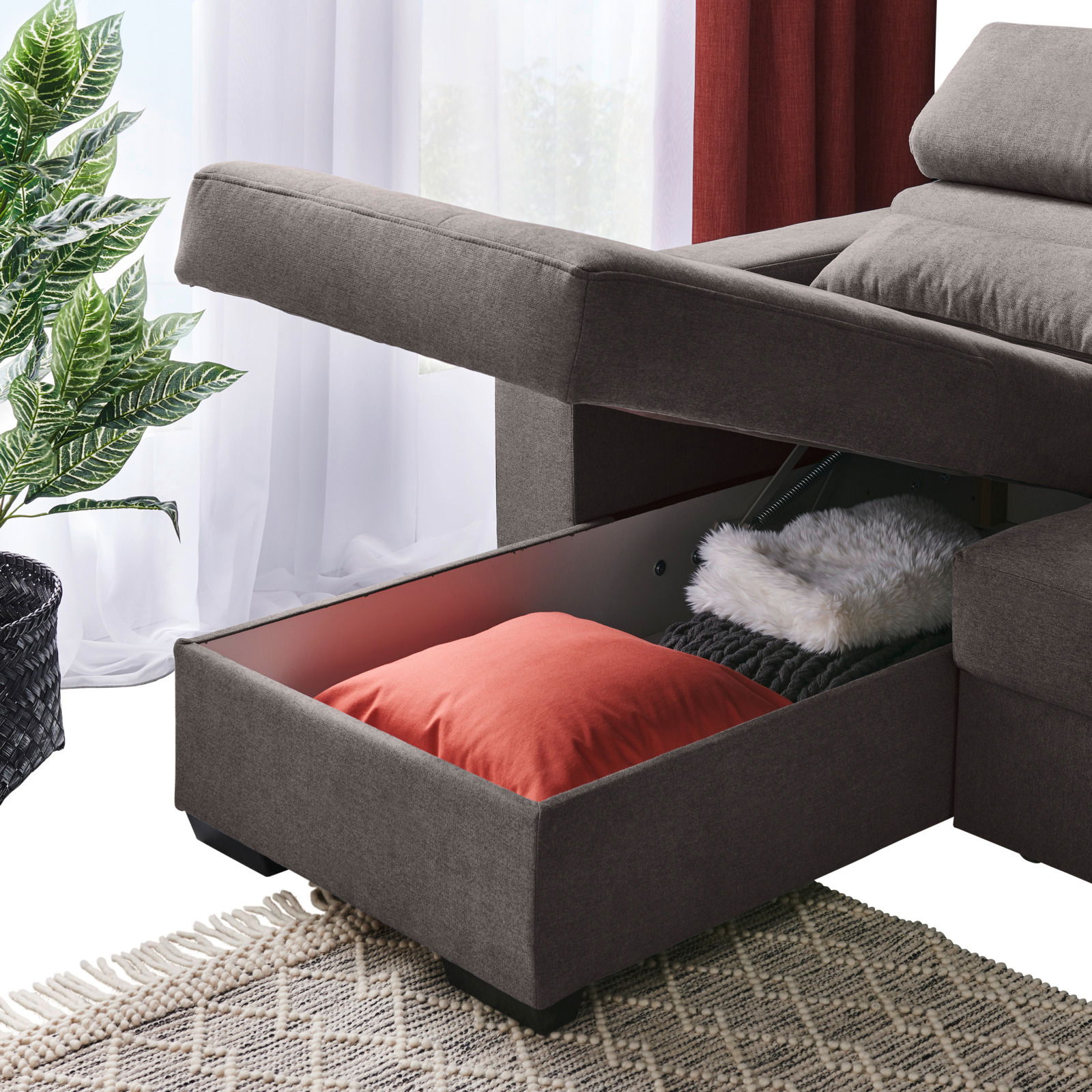 Graue Rundecke mit Stauraum, geöffnet, mit Kissen und Decke, seitliche Perspektive