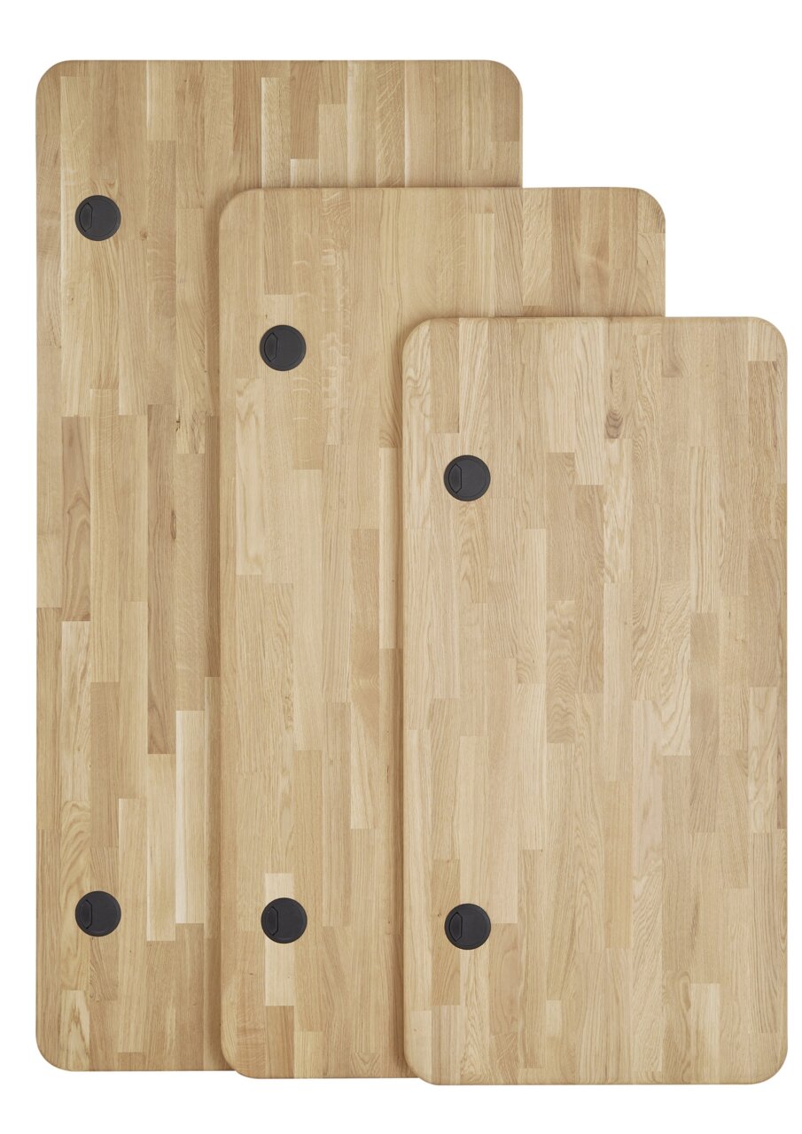 Drei Holzplatten in verschiedenen Größen mit abgerundeten Ecken und Kabeldurchführungen, aus der Vogelperspektive fotografiert.
