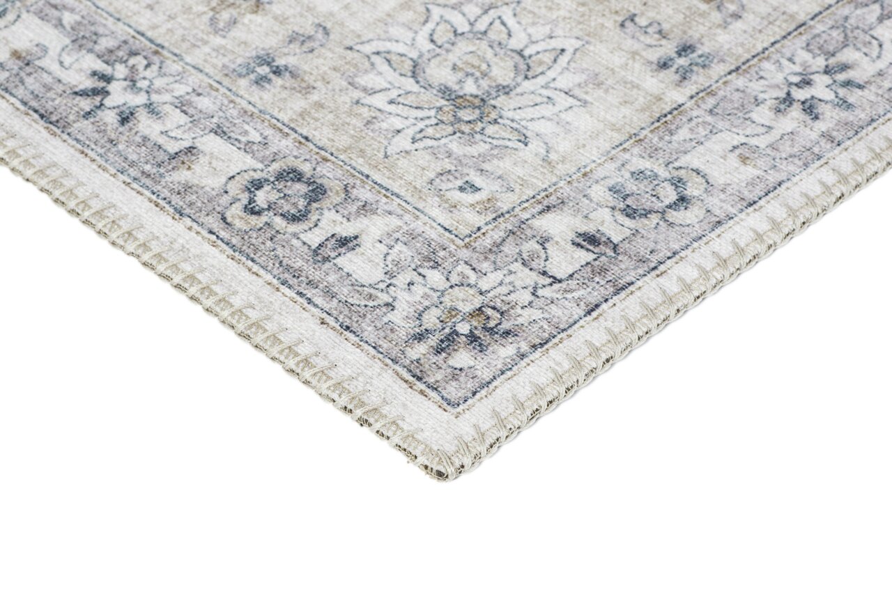 Ecke eines Teppichs mit floralen Mustern in sanften Beige- und Blautönen, von oben betrachtet.