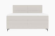 Frontale Ansicht eines modernen Boxspringbetts in hellem Stoffbezug mit schlichtem Design und schwarzen Füßen.