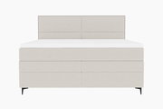 Frontale Ansicht eines modernen Boxspringbetts in hellem Stoffbezug mit schlichtem Design und schwarzen Füßen.