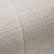 Nahaufnahme einer strukturierten, hellen Stoffoberfläche mit gewebtem Muster, perspektivisch von oben betrachtet.