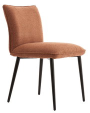 Gepolsterter Esszimmerstuhl ohne Armlehnen in rostbraunem Stoffbezug mit schwarzen Metallbeinen, schräg von vorne links fotografiert
