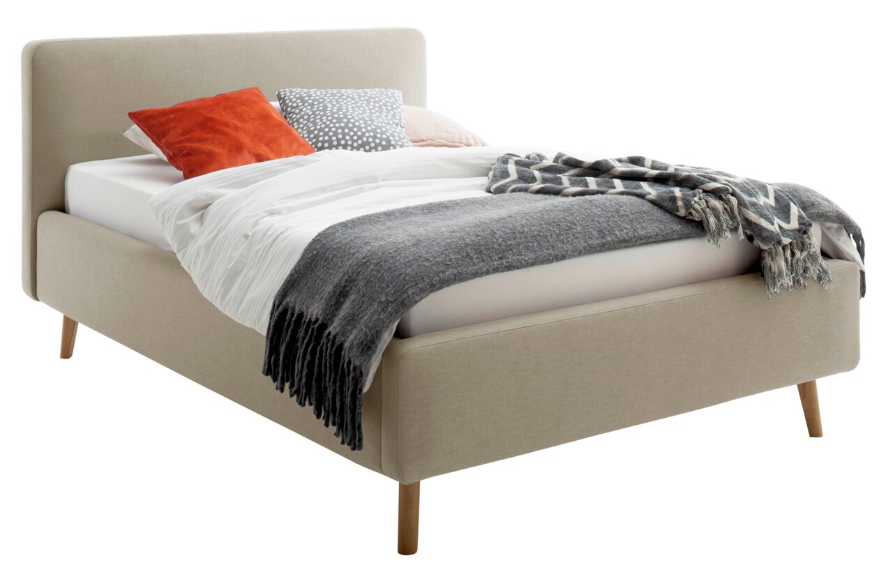 Beiges Polsterbett mit Holzfüßen, dekoriert mit Kissen und Decken, seitliche Perspektive