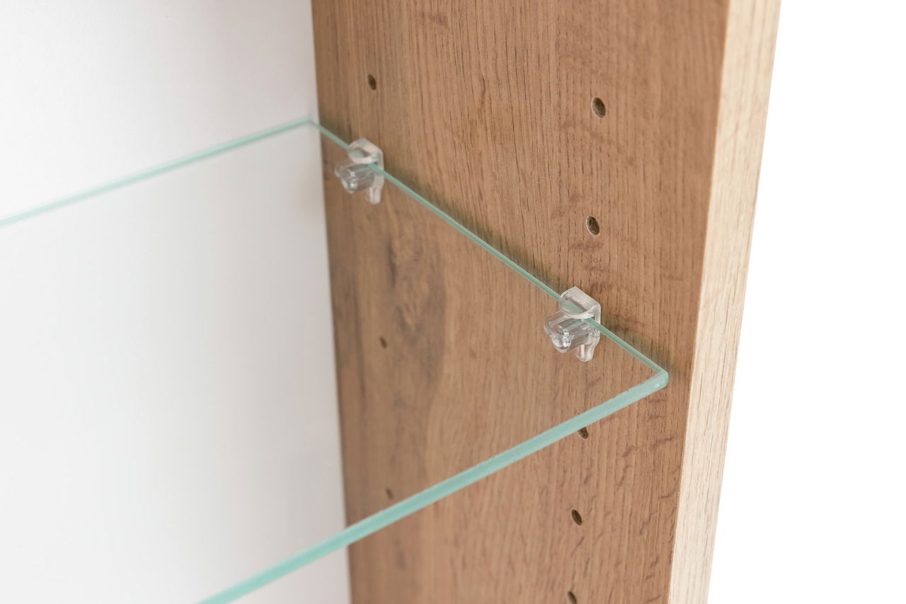 Nahaufnahme eines Spiegelschranks mit einem Glasregal, das an einer Holzwand befestigt ist. Perspektive von der Seite.