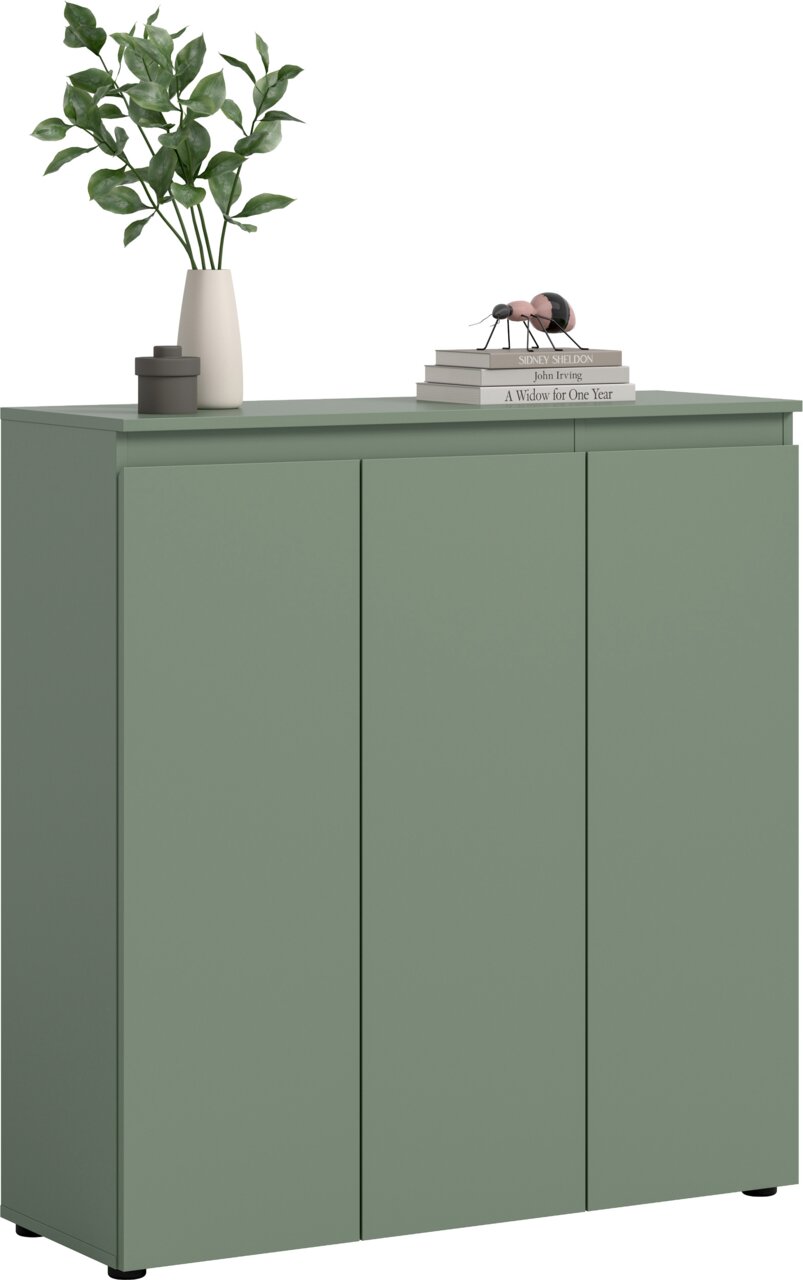 MID.YOU Universalschrank SCARPA Salbeigrünes Sideboard mit drei glatten Türen und schwarzem Sockel, frontal aus leicht schräger Perspektive von vorn fotografiert; oben Dekoration mit Vase und grünen Zweigen sowie Bücherstapel