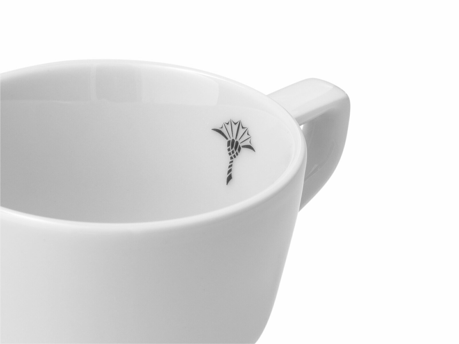 Nahaufnahme einer weißen Espressotasse mit einem schwarzen Logo auf der Innenseite, seitliche Perspektive.