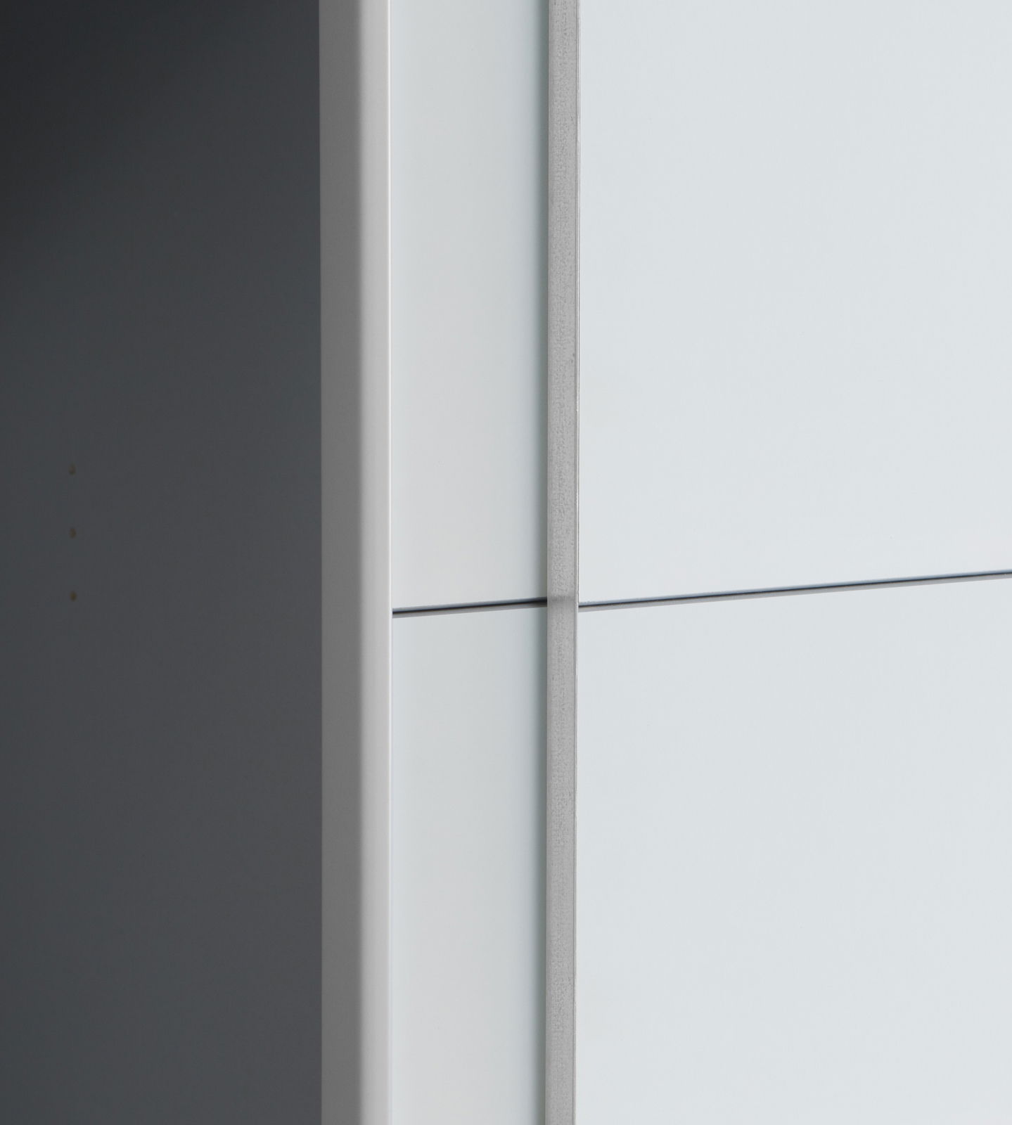 Nahaufnahme eines Dreh- und Schwebetürenschranks aus seitlicher Perspektive mit glatter, heller Oberfläche.