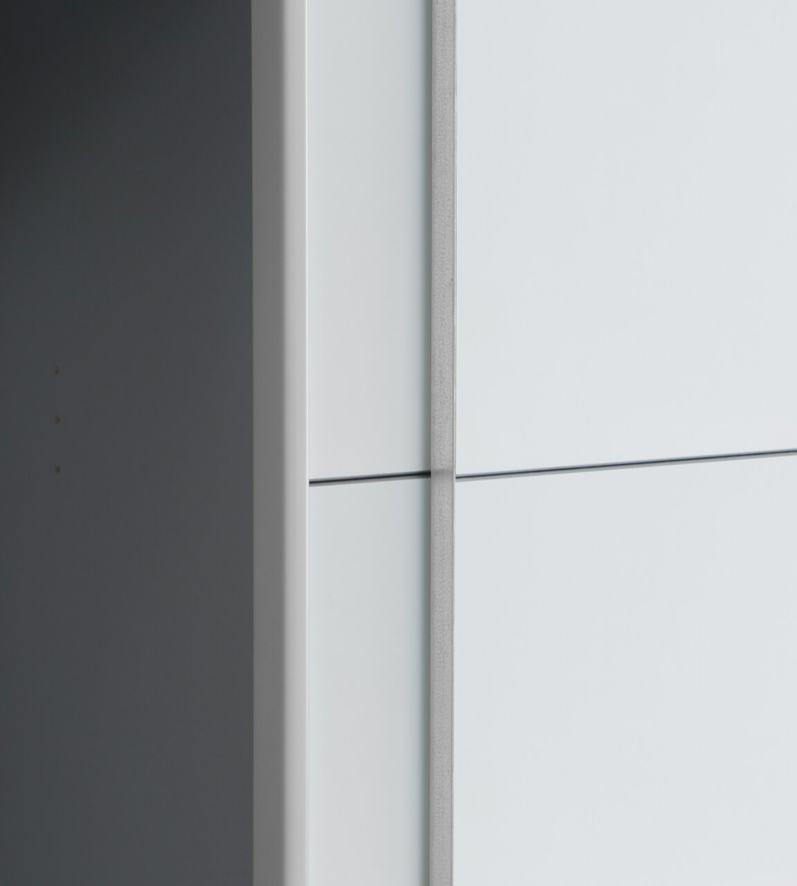 Nahaufnahme eines Dreh- und Schwebetürenschranks aus seitlicher Perspektive mit glatter, heller Oberfläche.