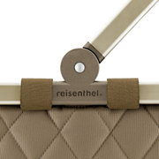 Close-up van het handvat van een Carrybag Rhombus Olive van reisenthel, met een olijfgroen ruitpatroon en een stevige metalen verbinding.