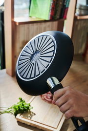 Pfanne mit 32 cm Durchmesser, von unten gezeigt, mit einem strukturierten Boden und einem ergonomischen Griff.