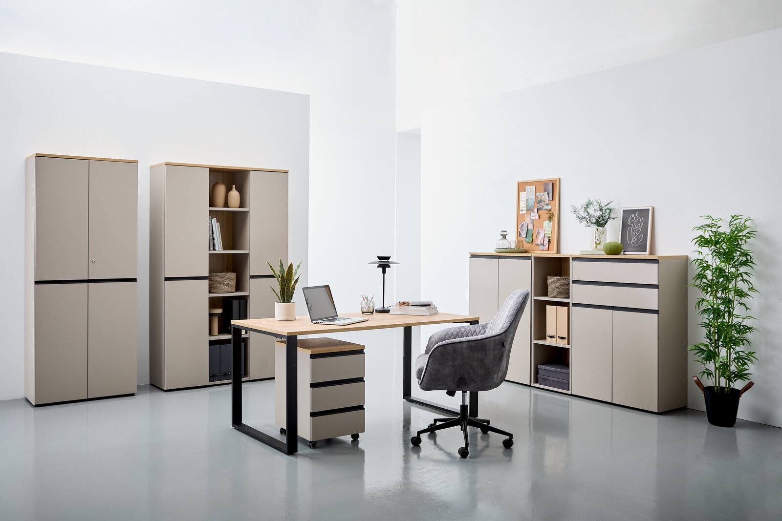 Moderne Büromöbel in einem hellen Raum, bestehend aus einem Schreibtisch mit Rollcontainer, mehreren Aktenschränken und einem Kombischrank. Perspektive von vorne.