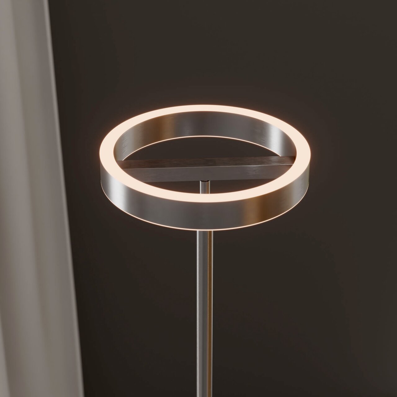 Moderne LED-Stehleuchte mit ringförmigem Leuchtkopf in gebürsteter Metalloptik, warmweiß leuchtend, Detailaufnahme aus leicht seitlicher Perspektive von oben vor dunklem Hintergrund