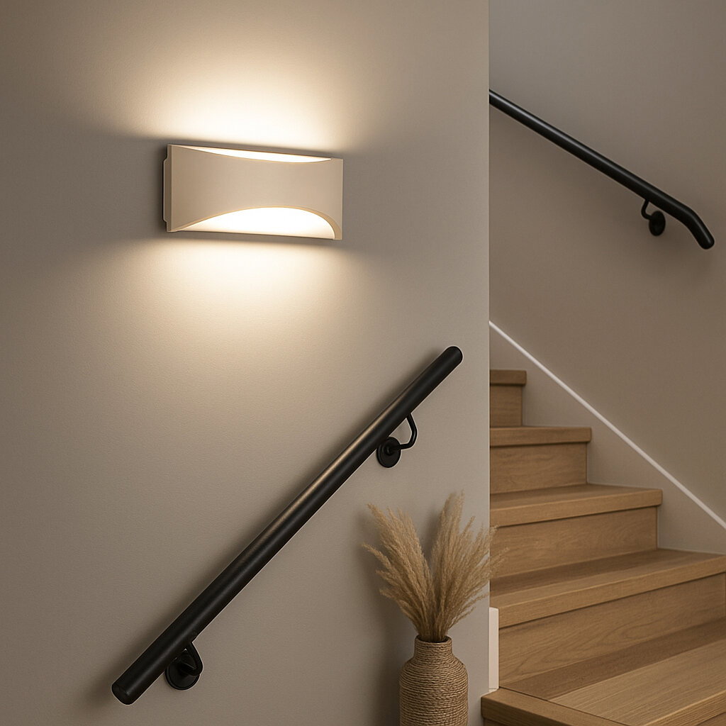 Moderne weiße Wandleuchte im Treppenhaus, die warmes Licht nach oben und unten abstrahlt; Perspektive: seitliche Frontansicht auf die Leuchte an der Wand neben der Treppe.