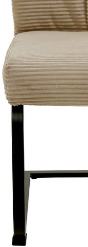 Nahaufnahme eines Schwingstuhls mit beigem, geripptem Stoffbezug und schwarzem Metallgestell, seitliche Perspektive.